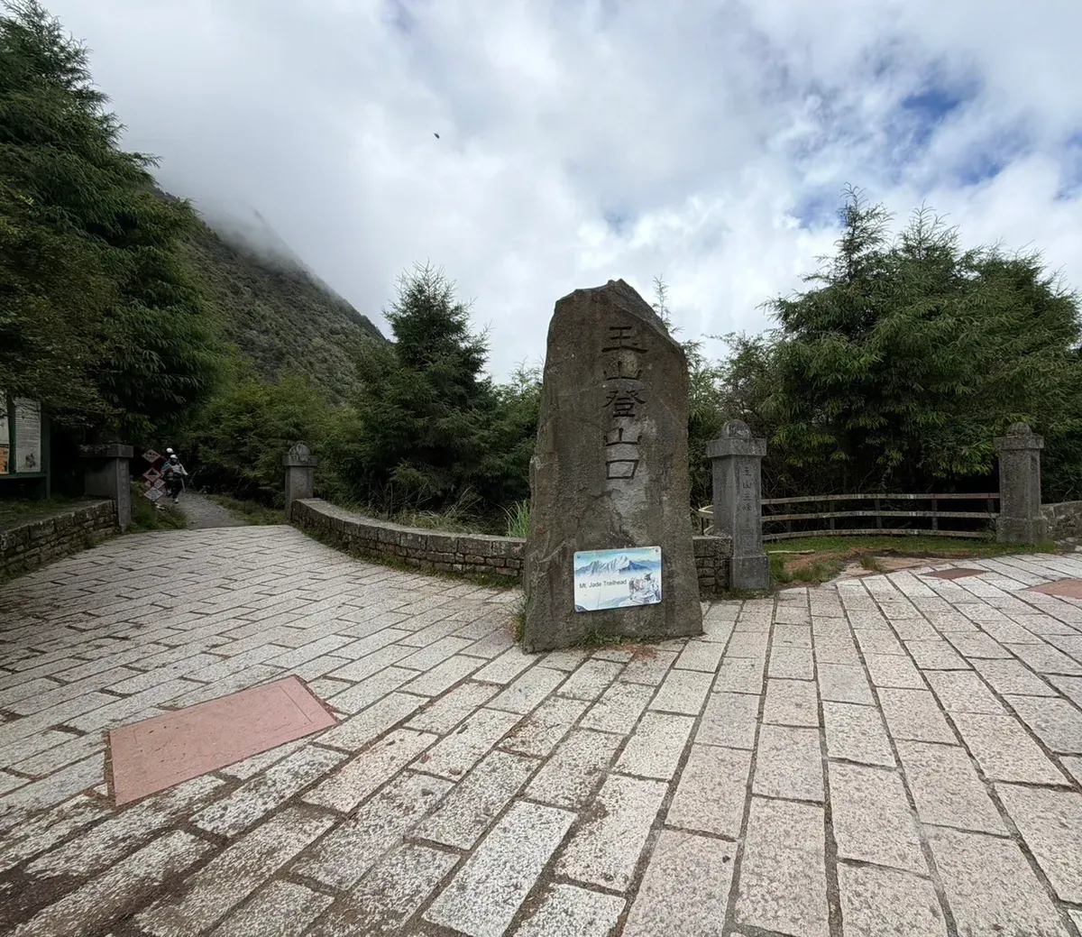 玉山登山口的石碑,刻著「玉山登山口 Mt. Jade Trailhead」,後方山頭罩在雲霧裡