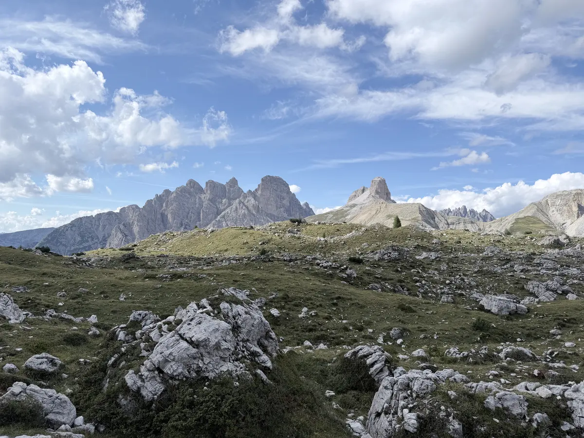 往 Malga Langalm 的回程路上，草地間散落大量白色岩塊，遠方是鋸齒狀的山脈
