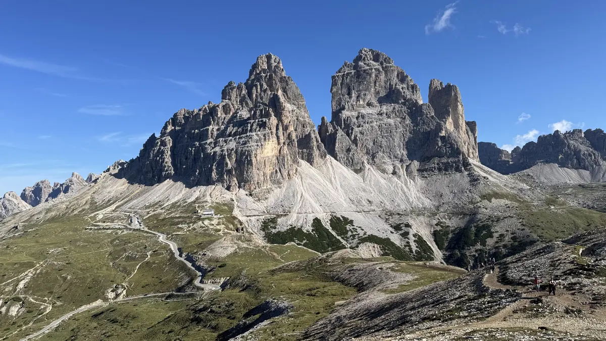 早上 9 點多往 Cadini di Misurina 的路上，藍天下的三尖峰南面，山腳下是蜿蜒的收費道路