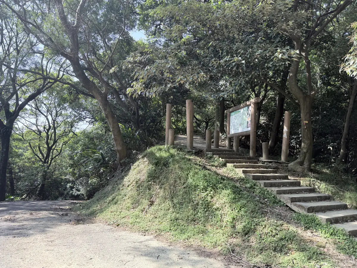 車道旁往上的水泥階梯步道入口，有木柱門和步道導覽看板